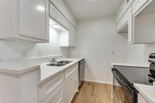 a kitchen with granite countertop a sink stove and cabinets