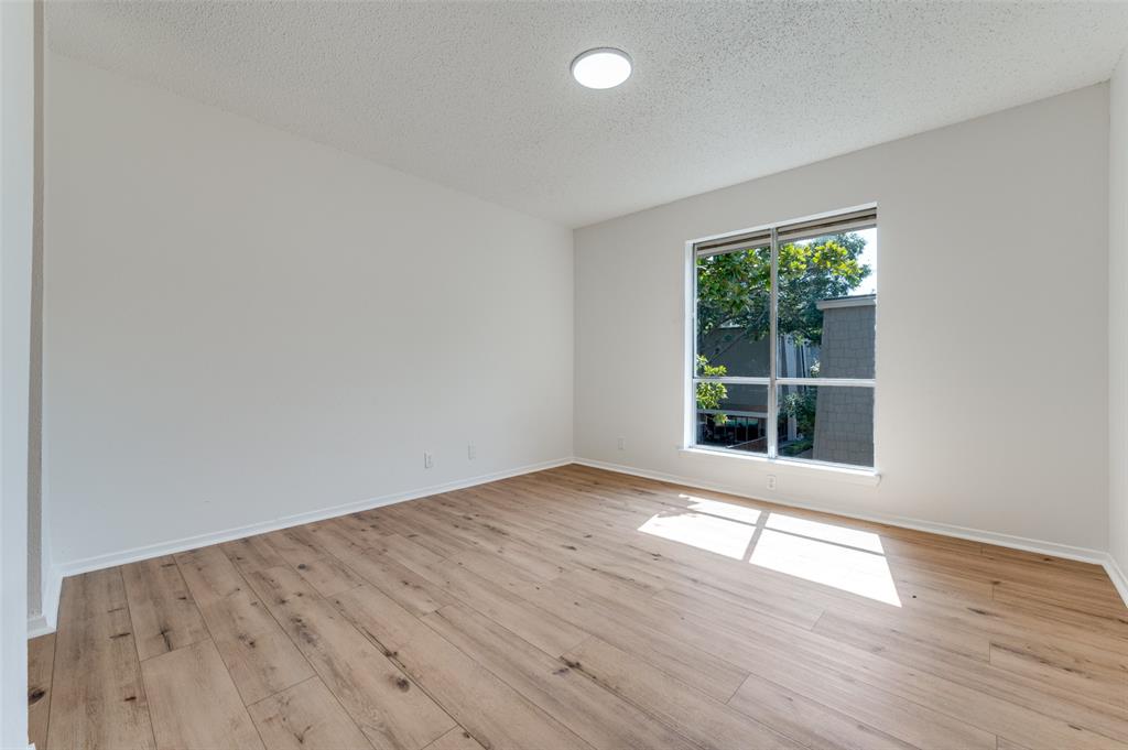 4859 Cedar Springs Road, Unit 337 Dallas, TX 75219 - Photo 6 of 27 an empty room with wooden floor and windows