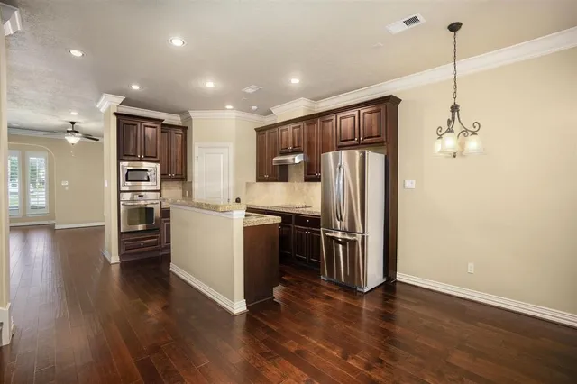 a kitchen with stainless steel appliances granite countertop a refrigerator and a stove top oven