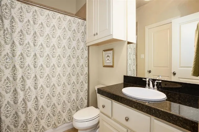 a view of wooden floor and a chandelier fan in a room