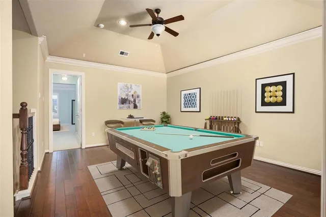 an empty room with wooden floor and ceiling fan