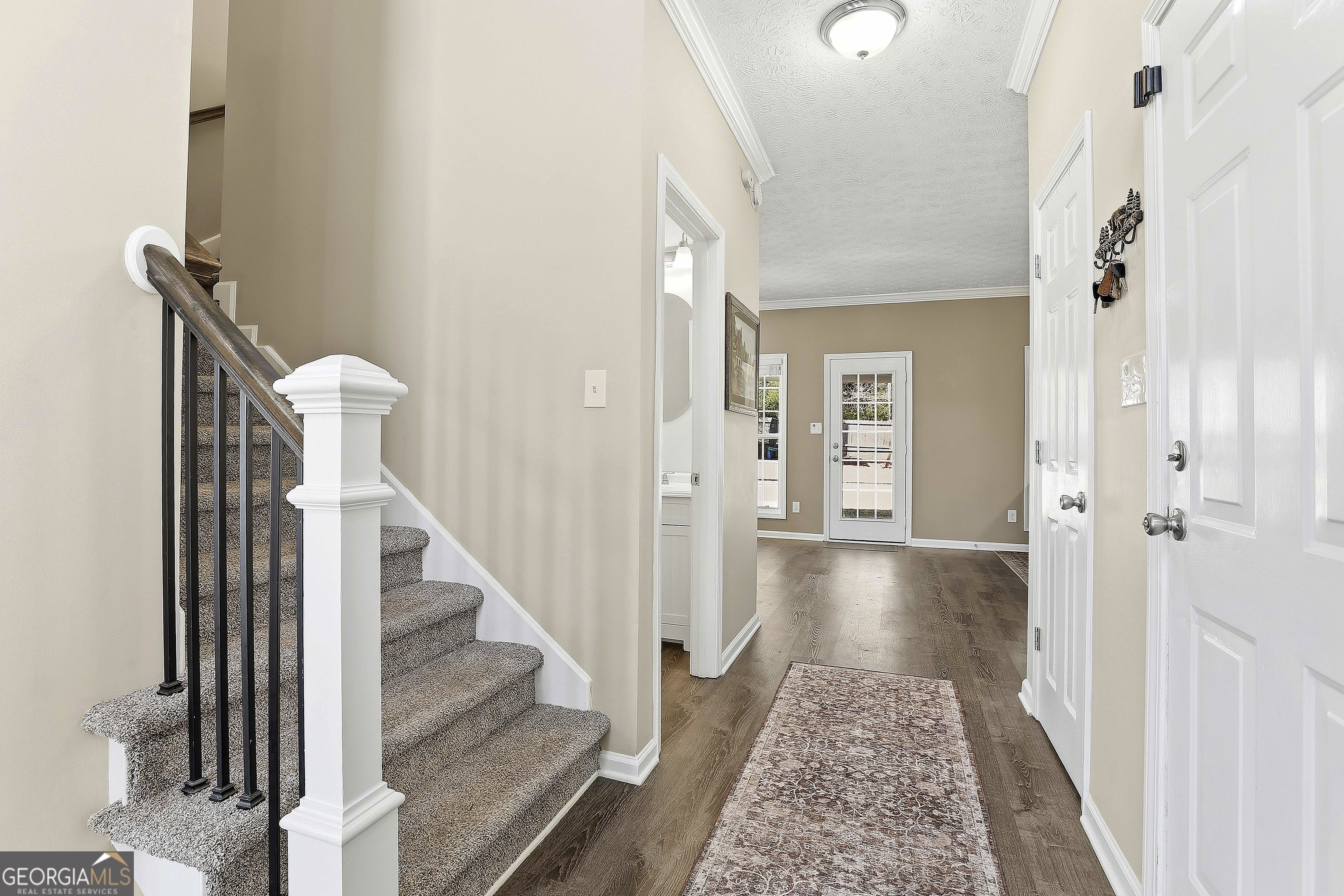 320 Emerald Way Senoia, GA 30276 - Photo 14 of 57 a view of a hallway with wooden floor and staircase