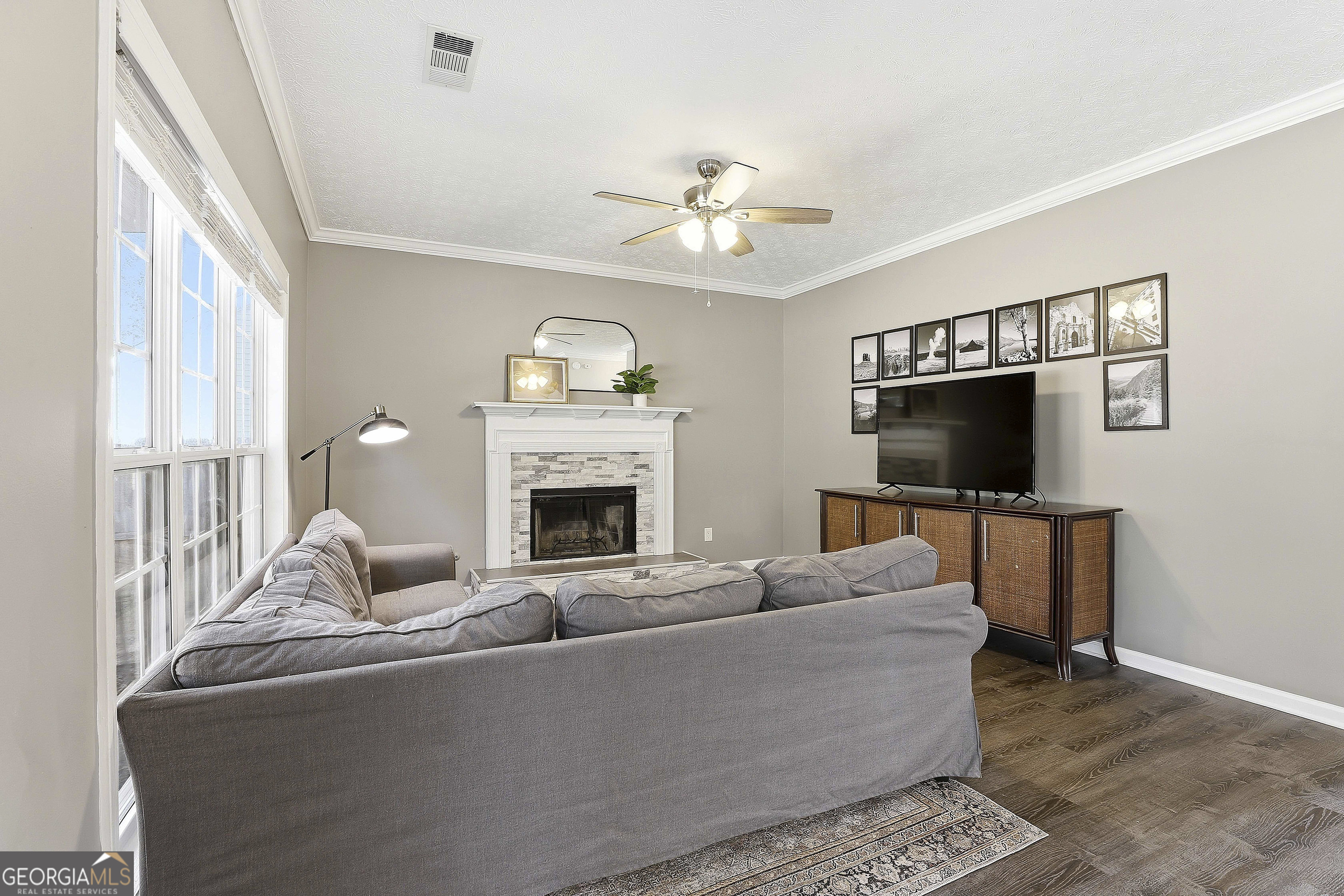 320 Emerald Way Senoia, GA 30276 - Photo 16 of 57 a living room with furniture a flat screen tv and a fireplace