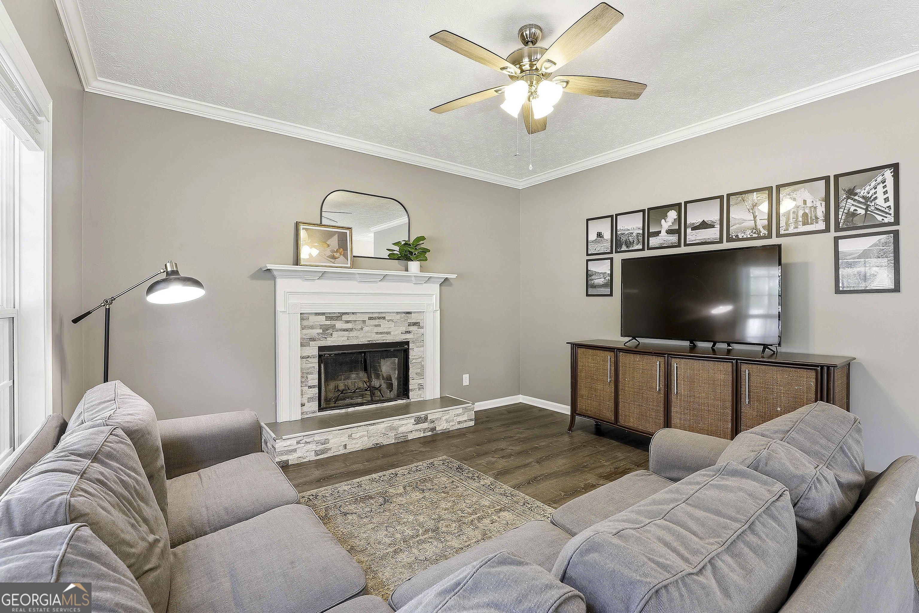320 Emerald Way Senoia, GA 30276 - Photo 17 of 57 a living room with furniture a flat screen tv and a fireplace