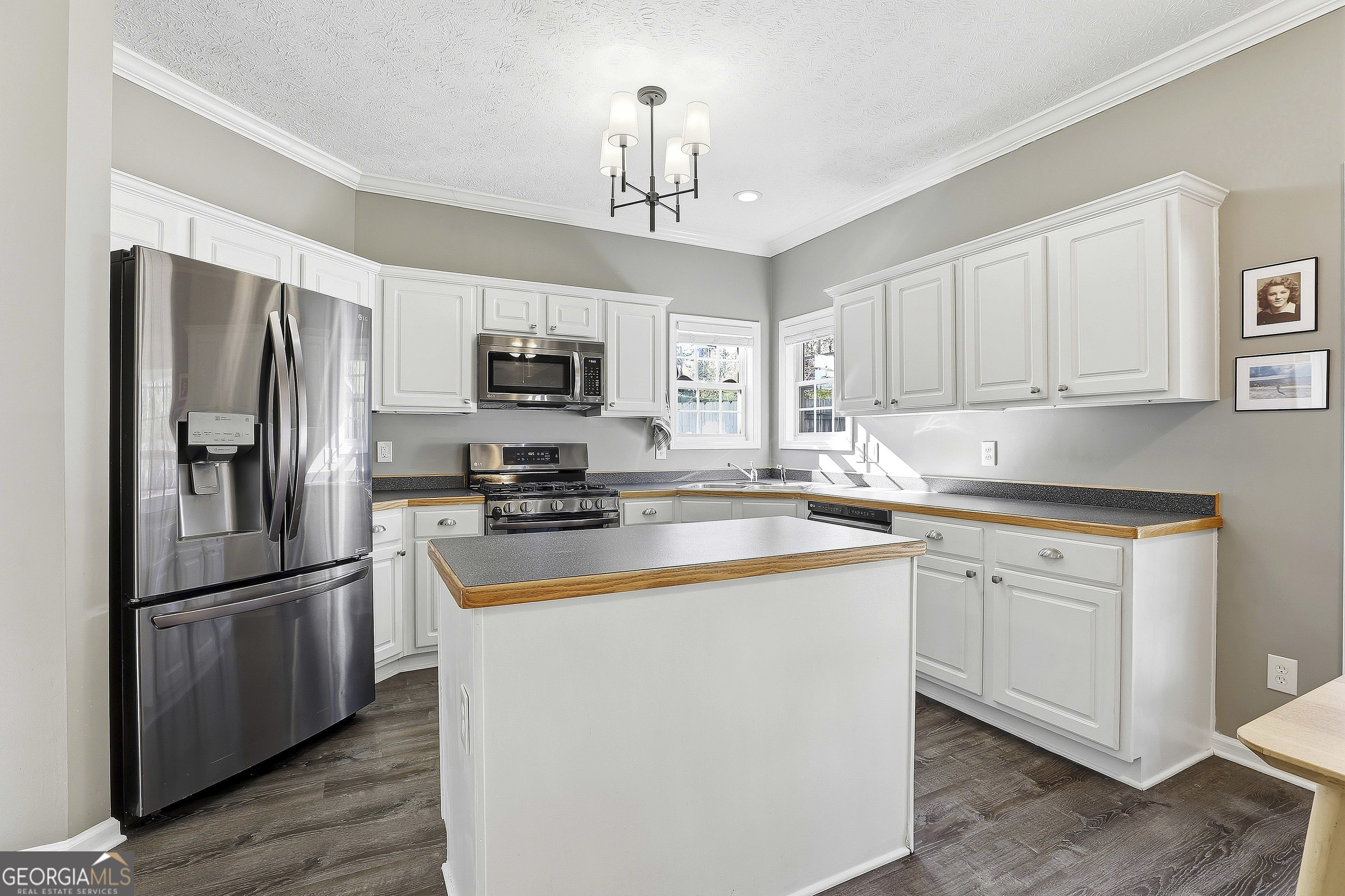320 Emerald Way Senoia, GA 30276 - Photo 22 of 57 a kitchen with kitchen island a refrigerator cabinets and wooden floor