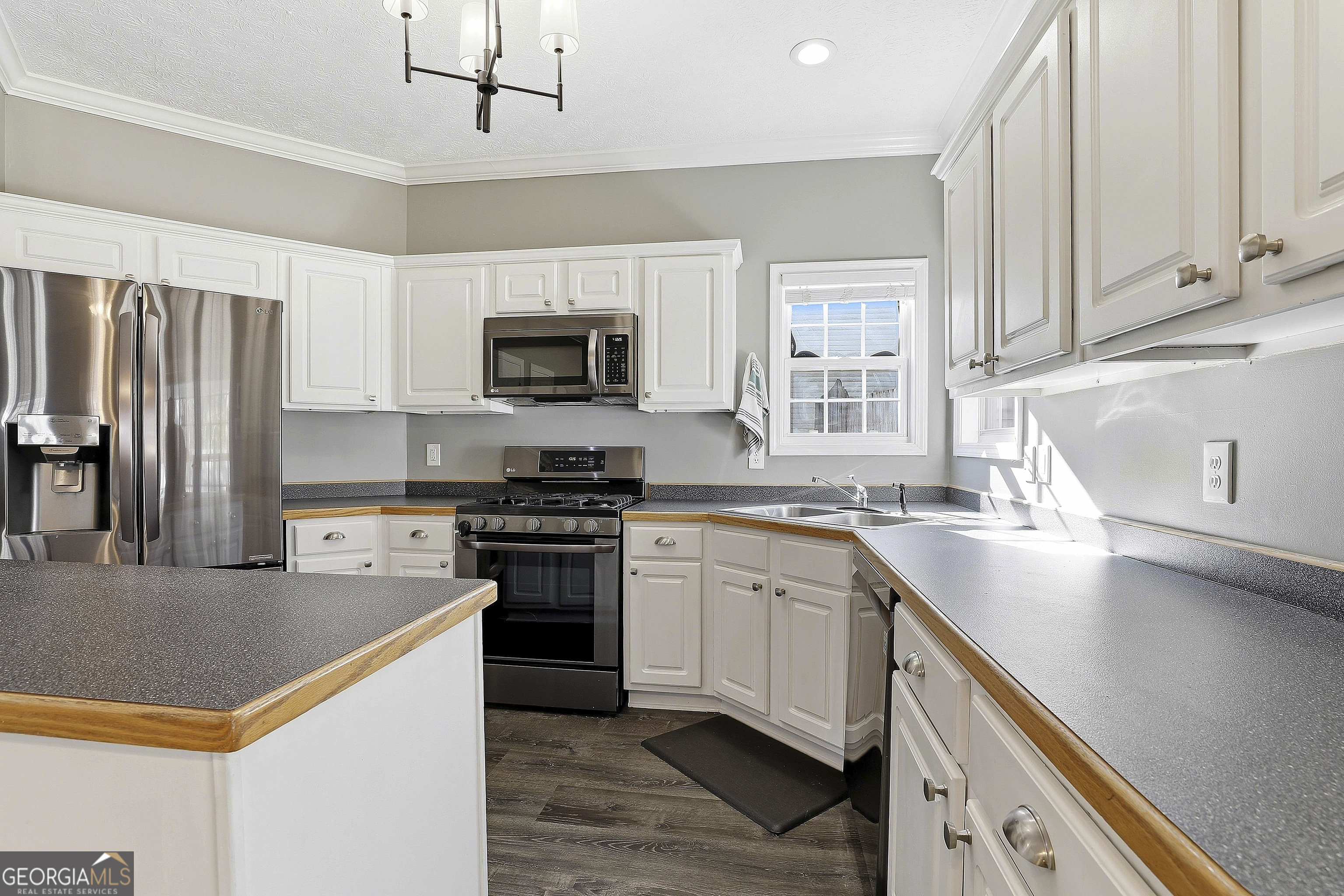 320 Emerald Way Senoia, GA 30276 - Photo 23 of 57 a kitchen with stainless steel appliances granite countertop a sink a stove a refrigerator cabinets and a window