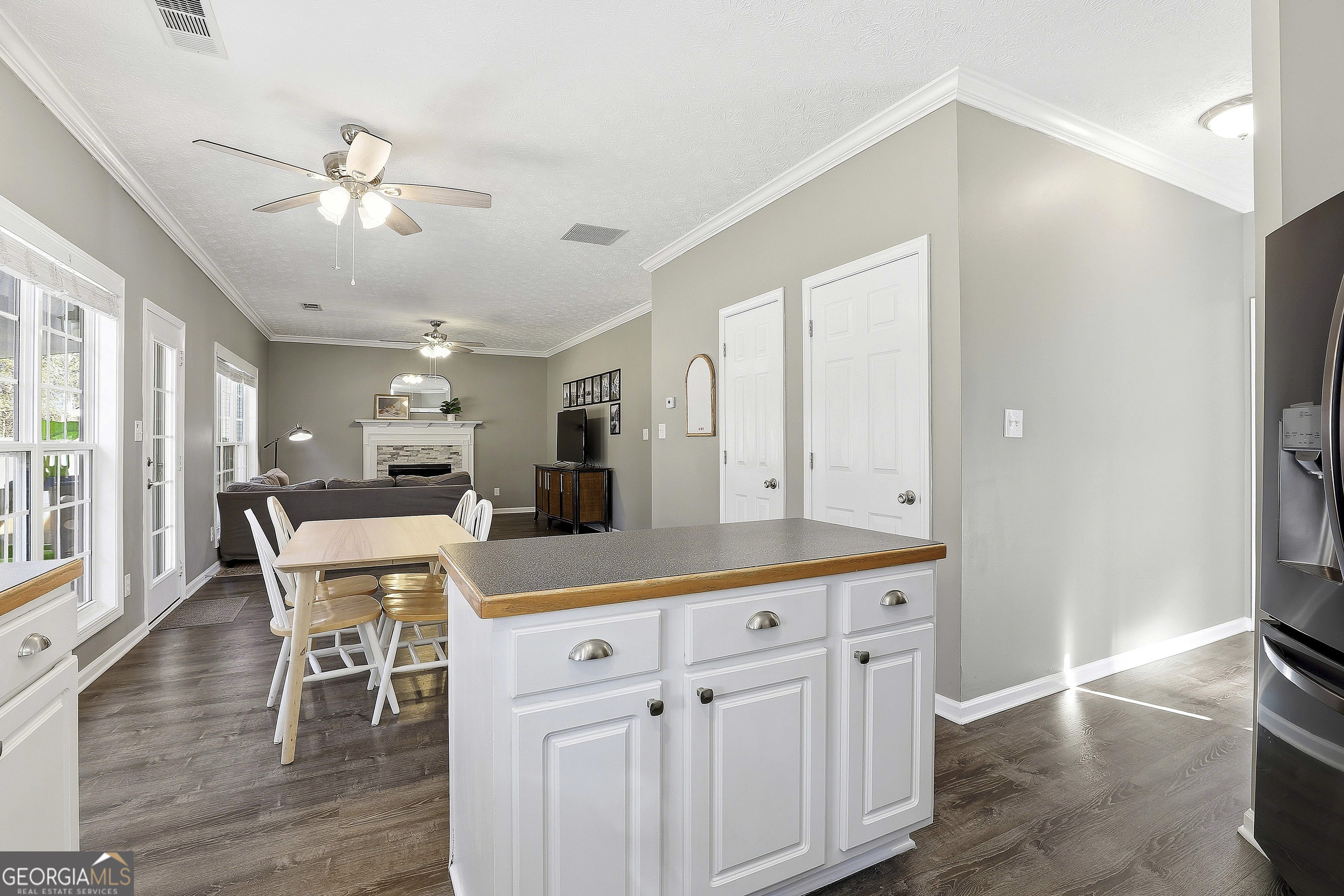 320 Emerald Way Senoia, GA 30276 - Photo 25 of 57 a kitchen with stainless steel appliances kitchen island granite countertop a refrigerator a stove a dining table and chairs with wooden floor
