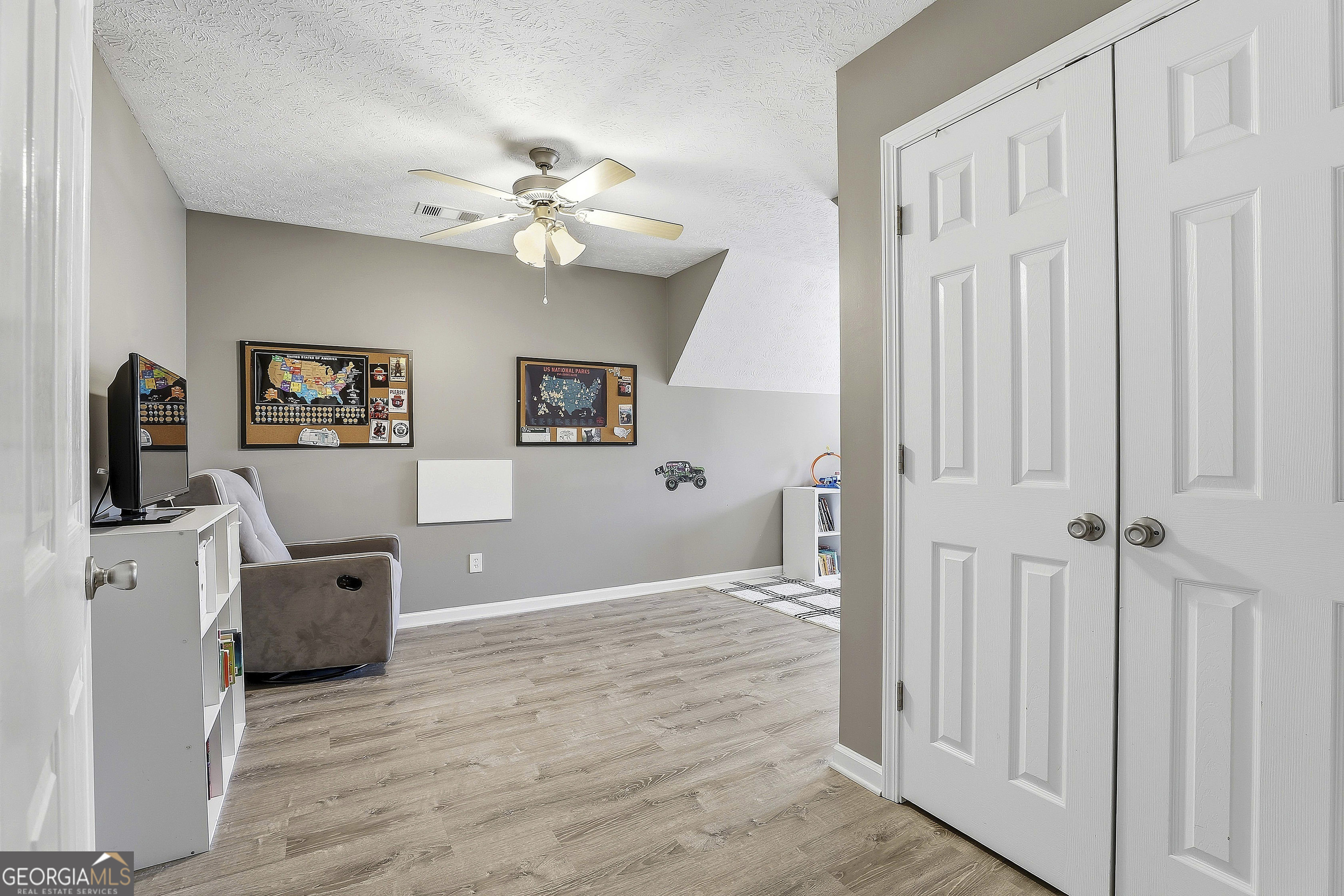 320 Emerald Way Senoia, GA 30276 - Photo 38 of 57 a view of a livingroom with a chandelier fan and wooden floor