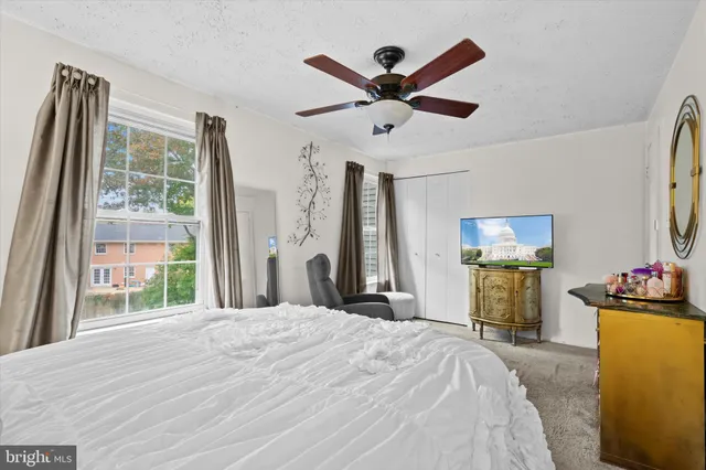 a bedroom with a bed and a large window