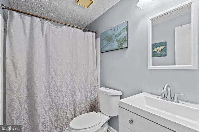 a white toilet sitting next to a bathroom sink