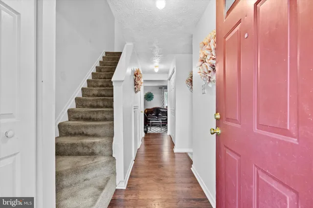 a view of a hallway with wooden floor and entryway