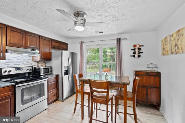 a dining room with furniture a window and wooden floor