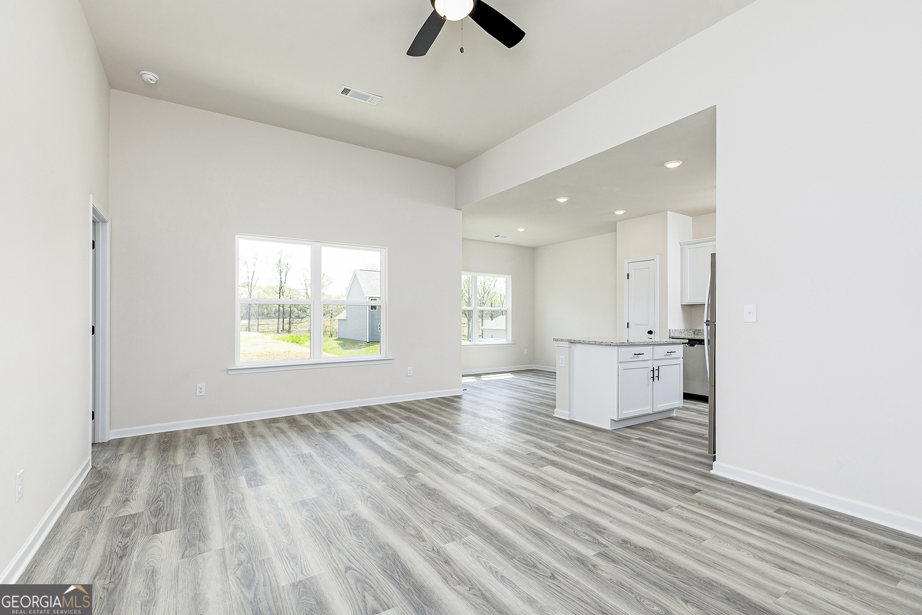 217 Darter Court Hoschton, GA 30548 - Photo 5 of 23 an empty room with wooden floor and windows
