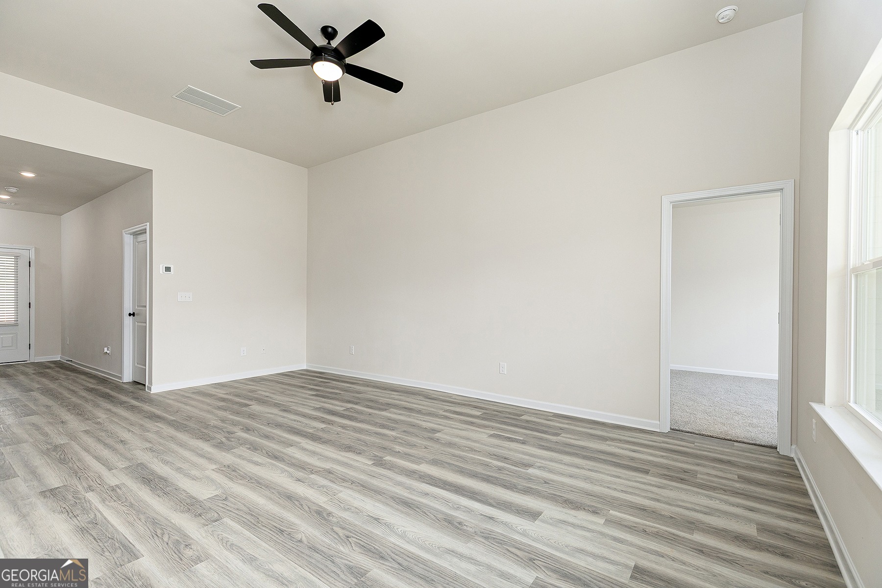 217 Darter Court Hoschton, GA 30548 - Photo 7 of 23 wooden floor in an empty room with a window