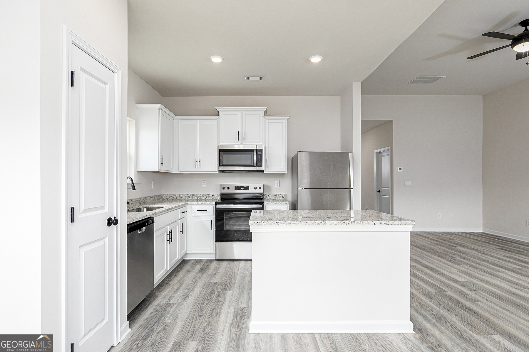 217 Darter Court Hoschton, GA 30548 - Photo 8 of 23 a kitchen with stainless steel appliances a sink stove refrigerator and cabinets