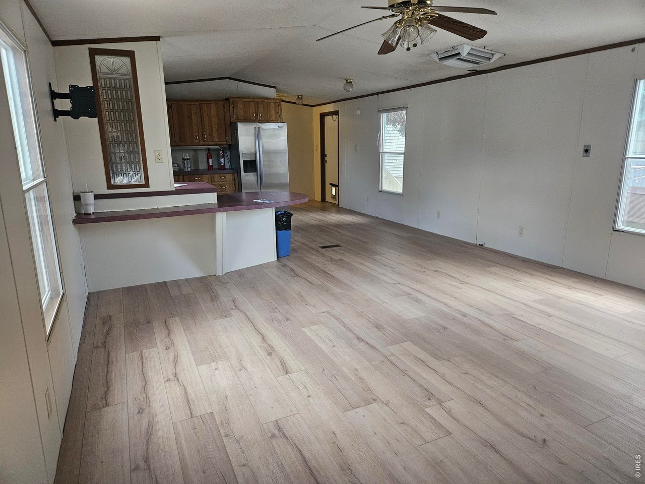 230 North 2nd Street, Unit 59 Berthoud, CO 80513 - Photo 4 of 19 a view of a kitchen with a sink a window and wooden floor