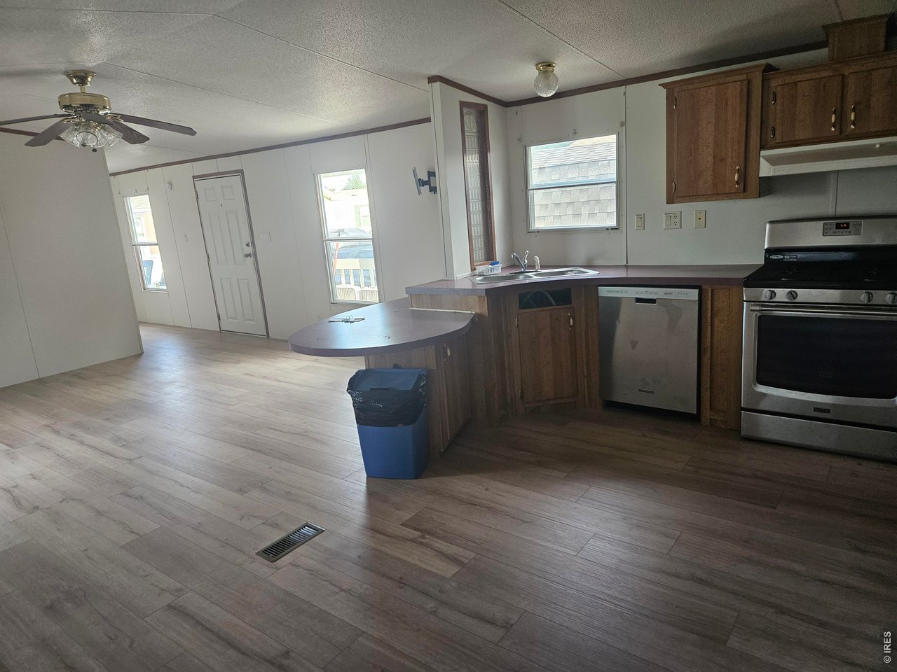 230 North 2nd Street, Unit 59 Berthoud, CO 80513 - Photo 9 of 19 a kitchen with stainless steel appliances granite countertop a sink cabinets and wooden floor