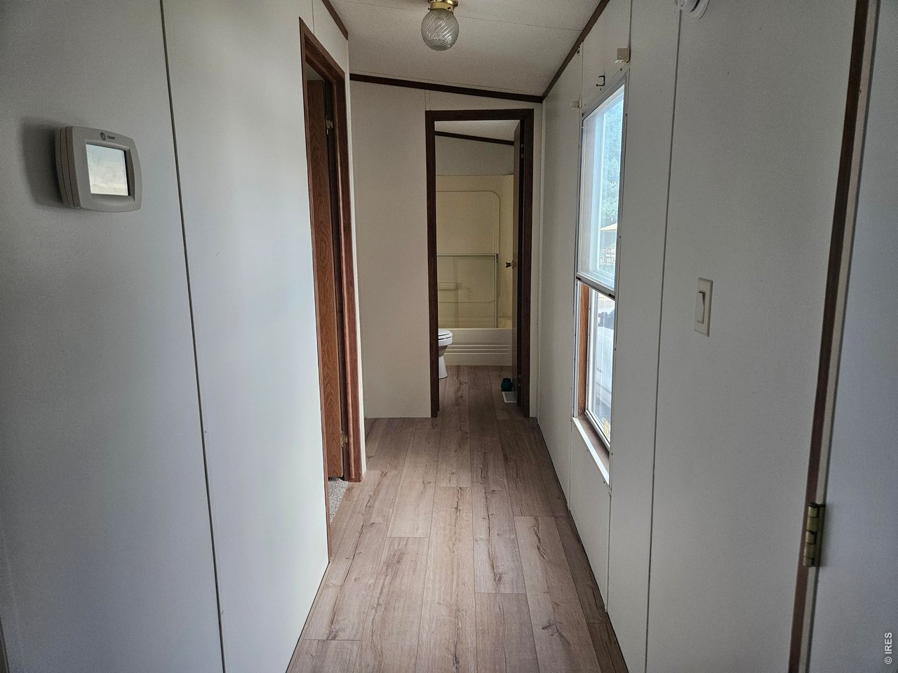 230 North 2nd Street, Unit 59 Berthoud, CO 80513 - Photo 10 of 19 a view of a hallway with wooden floor and a glass door