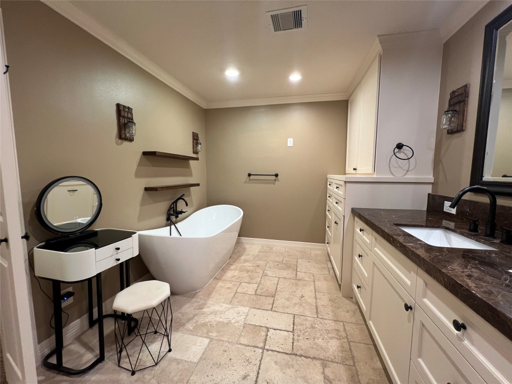 1014 Roxella Street Houston, TX 77076 - Photo 21 of 30 a bathroom with a granite countertop toilet a sink and a mirror