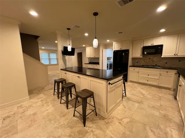 a large kitchen with a table and chairs