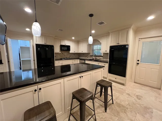 a kitchen with stainless steel appliances granite countertop a refrigerator and a sink