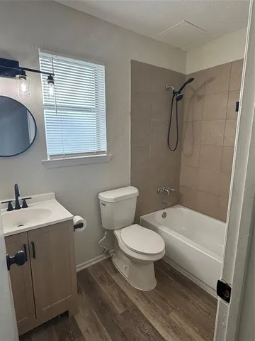 a bathroom with a granite countertop toilet a sink and a bathtub