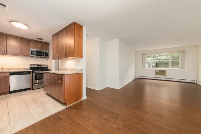 a kitchen with granite countertop a refrigerator and a stove top oven