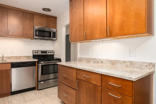 a kitchen with stainless steel appliances granite countertop a sink stove and microwave