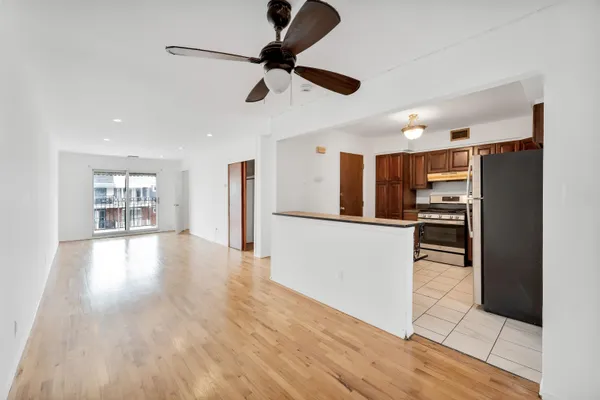 a view of a kitchen with refrigerator and wooden floor