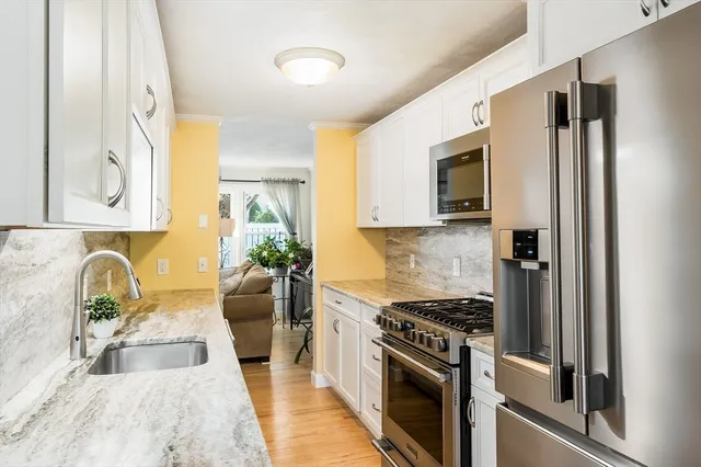 a kitchen with stainless steel appliances granite countertop a refrigerator stove and sink
