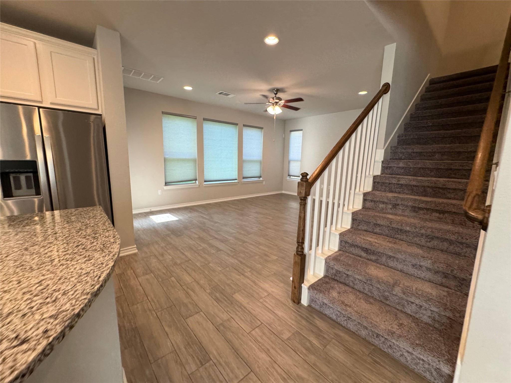 14100 McCoy Loop, Unit 1 Austin, TX 78717 - Photo 9 of 39 A streamlined open-concept design unites the kitchen, living area, and a carpeted staircase for effortless flow.