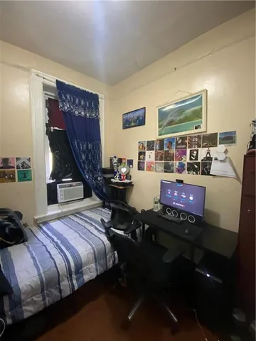 a bed sitting in a bedroom next to a window and dresser