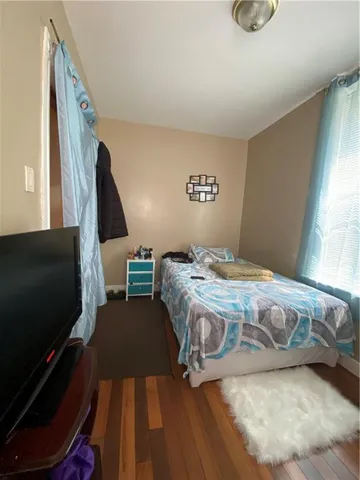 a bedroom with a bed a couch and a large window