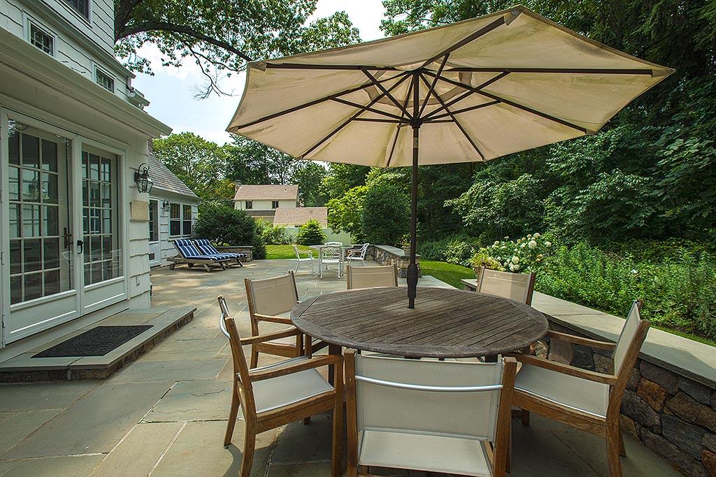 33 Birch Road Darien, CT 06820 - Photo 25 of 33 a patio with a table and chairs under an umbrella