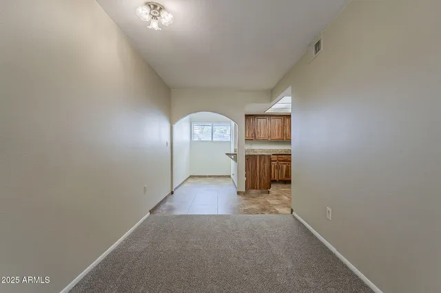 a view of a hallway with wooden floor and a kitchen