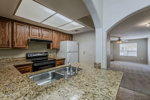 a kitchen with a stove a refrigerator and a sink