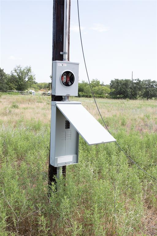 497 Big Sandy Road Newcastle, TX 76372 - Photo 6 of 22 Utility pole with a mounted electrical meter base and a gray panel box with an open door