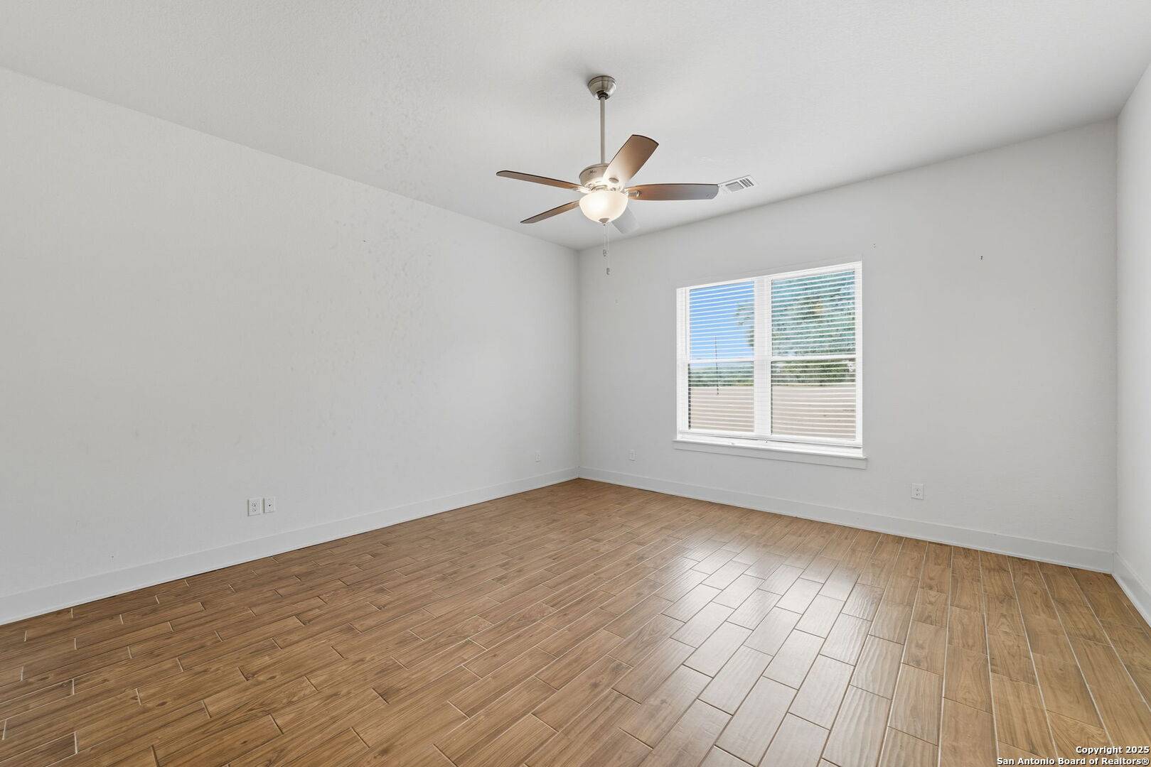 3172 Interstate 35 Natalia, TX 78059 - Photo 18 of 26 an empty room with wooden floor ceiling fan and window