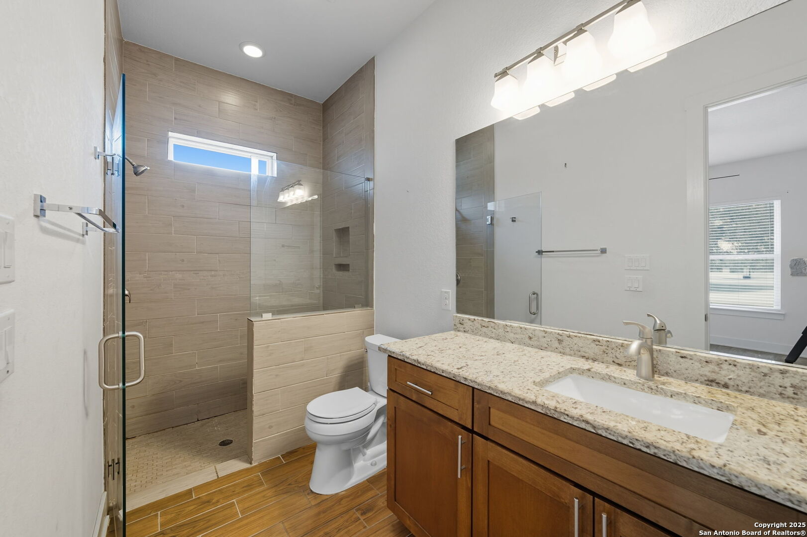 3172 Interstate 35 Natalia, TX 78059 - Photo 23 of 26 a bathroom with a granite countertop sink a toilet and shower