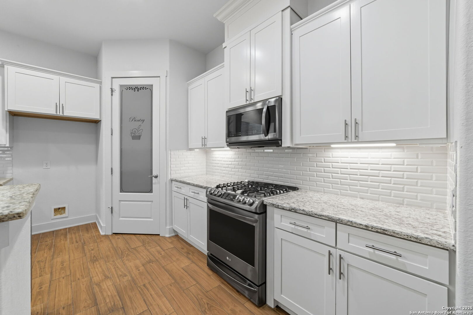 3172 Interstate 35 Natalia, TX 78059 - Photo 7 of 26 a kitchen with granite countertop cabinets stainless steel appliances and a wooden floor