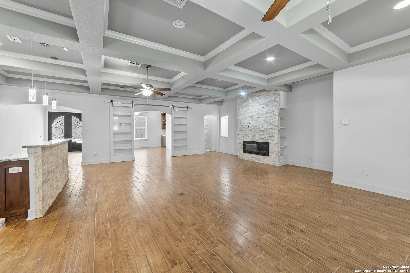 3172 Interstate 35 Natalia, TX 78059 - Photo 10 of 26 an empty room with wooden floor and a kitchen
