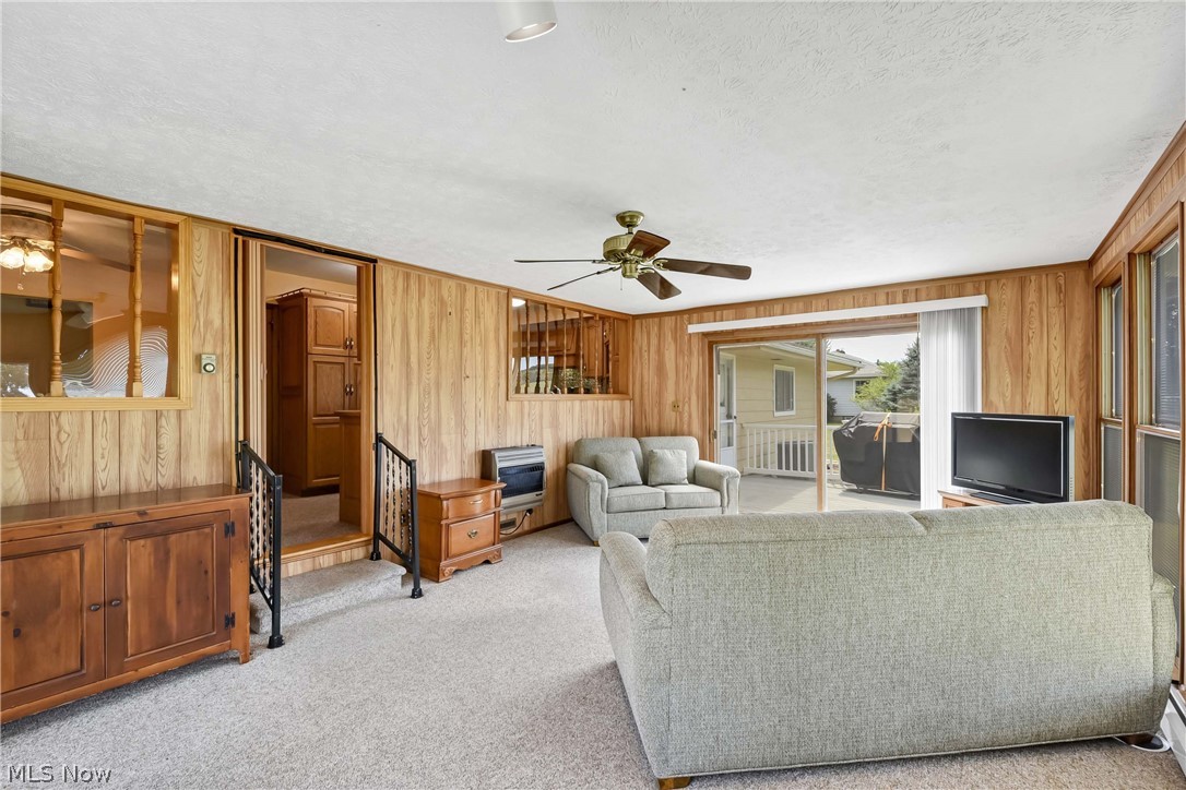 3690 Long Road Avon, OH 44011 - Photo 17 of 41 Sun room featuring a textured ceiling, wood walls, light colored carpet, and ceiling fan