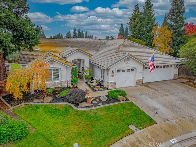 a view of a white house with a big yard and potted plants