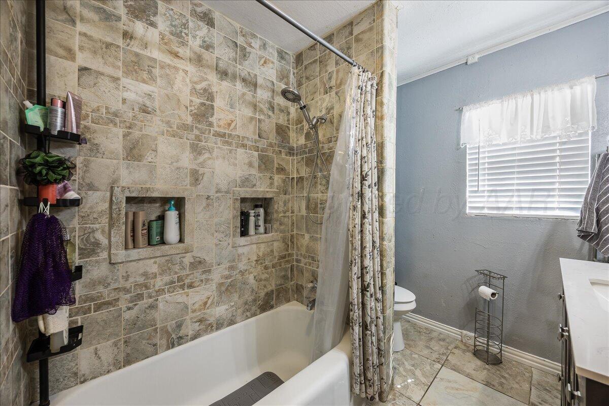 4011 Parker Street Amarillo, TX 79110 - Photo 12 of 17 a bathroom with a bathtub and a shower