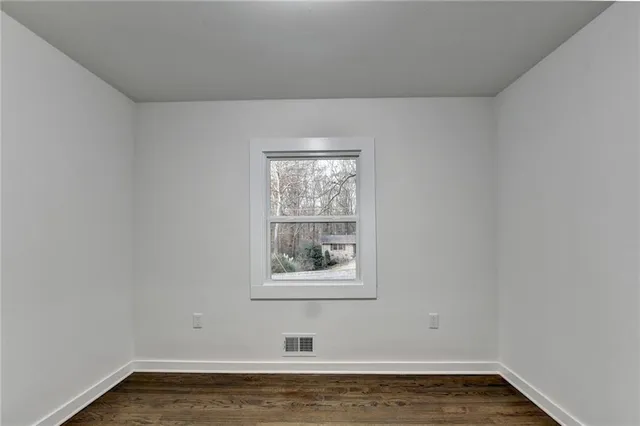 a bedroom with a large bed a chandelier and windows