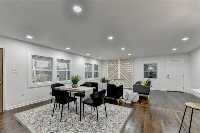 a living room with furniture a large window and wooden floor