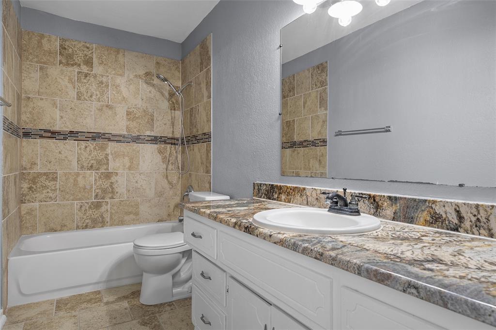 711 Rosedale Drive Hewitt, TX 76643 - Photo 9 of 16 a bathroom with a granite countertop sink a toilet and bathtub