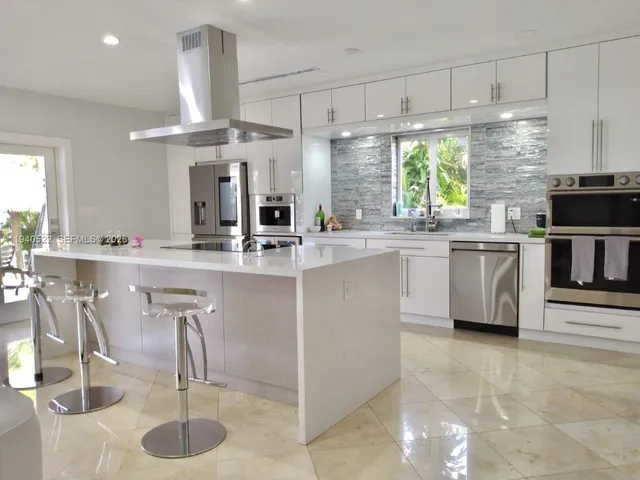 a living room with furniture and a dining table with kitchen view