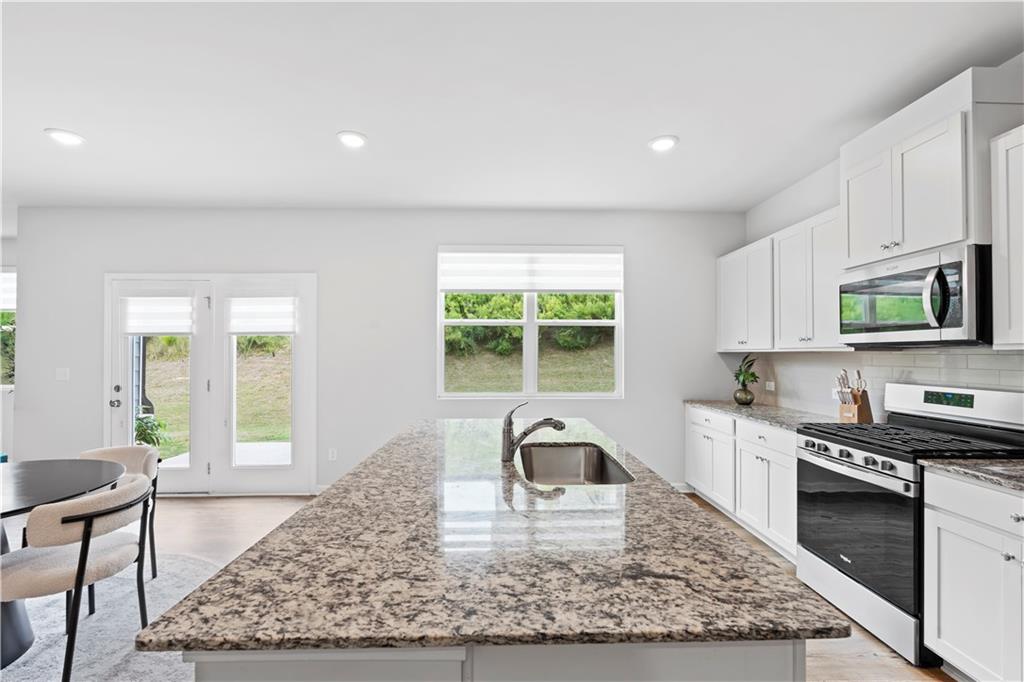 4780 Mock Orange Street Atlanta, GA 30331 - Photo 18 of 47 a kitchen with stainless steel appliances granite countertop a stove top oven a sink a counter space and cabinets