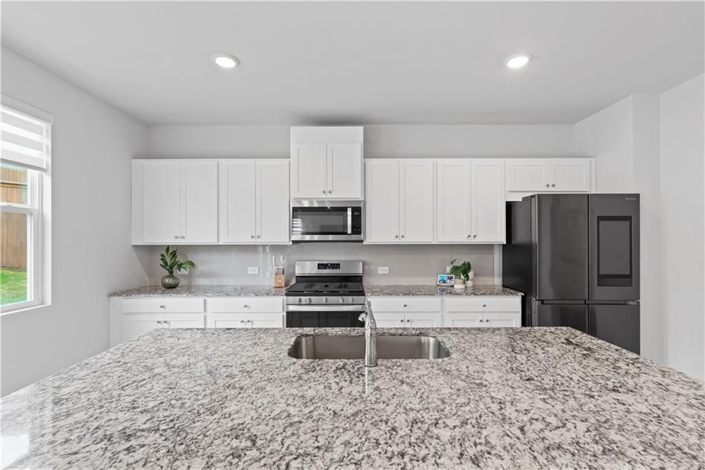 4780 Mock Orange Street Atlanta, GA 30331 - Photo 22 of 47 a kitchen with stainless steel appliances granite countertop a sink stove and refrigerator